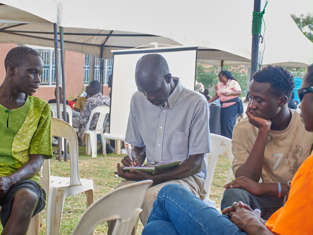 A Roots of Hope Uganda volunteer taking notes during outreach